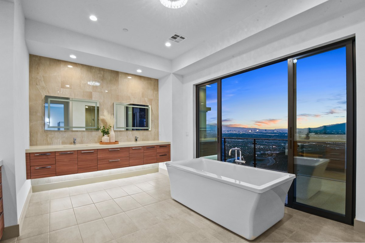 Luxury Las Vegas home staging highlights a serene, city-view bathroom retreat. | Utopia Luxury Home Staging & Design