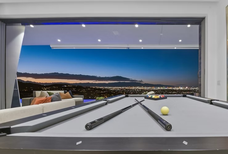 Upscale home staging highlights a billiard room with stunning city views. | Utopia Luxury Home Staging & Design